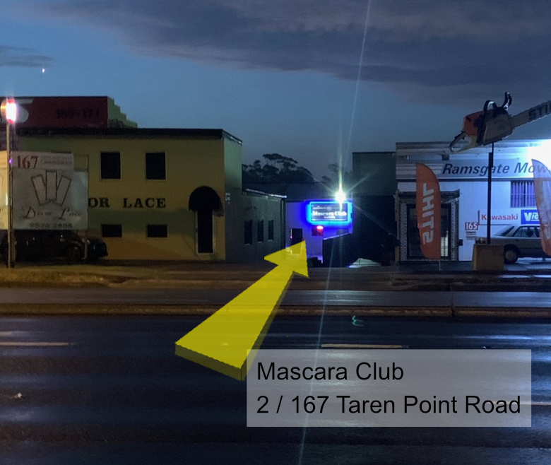 A view of 167 Mascara Club from the street at night.
